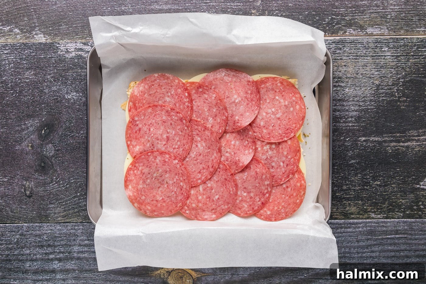 Layer of hard salami over the provolone cheese on sliders.