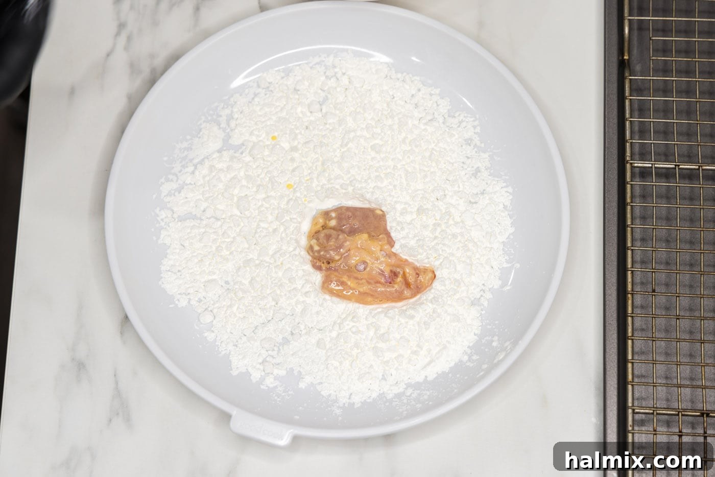 coating chicken piece in cornstarch before frying