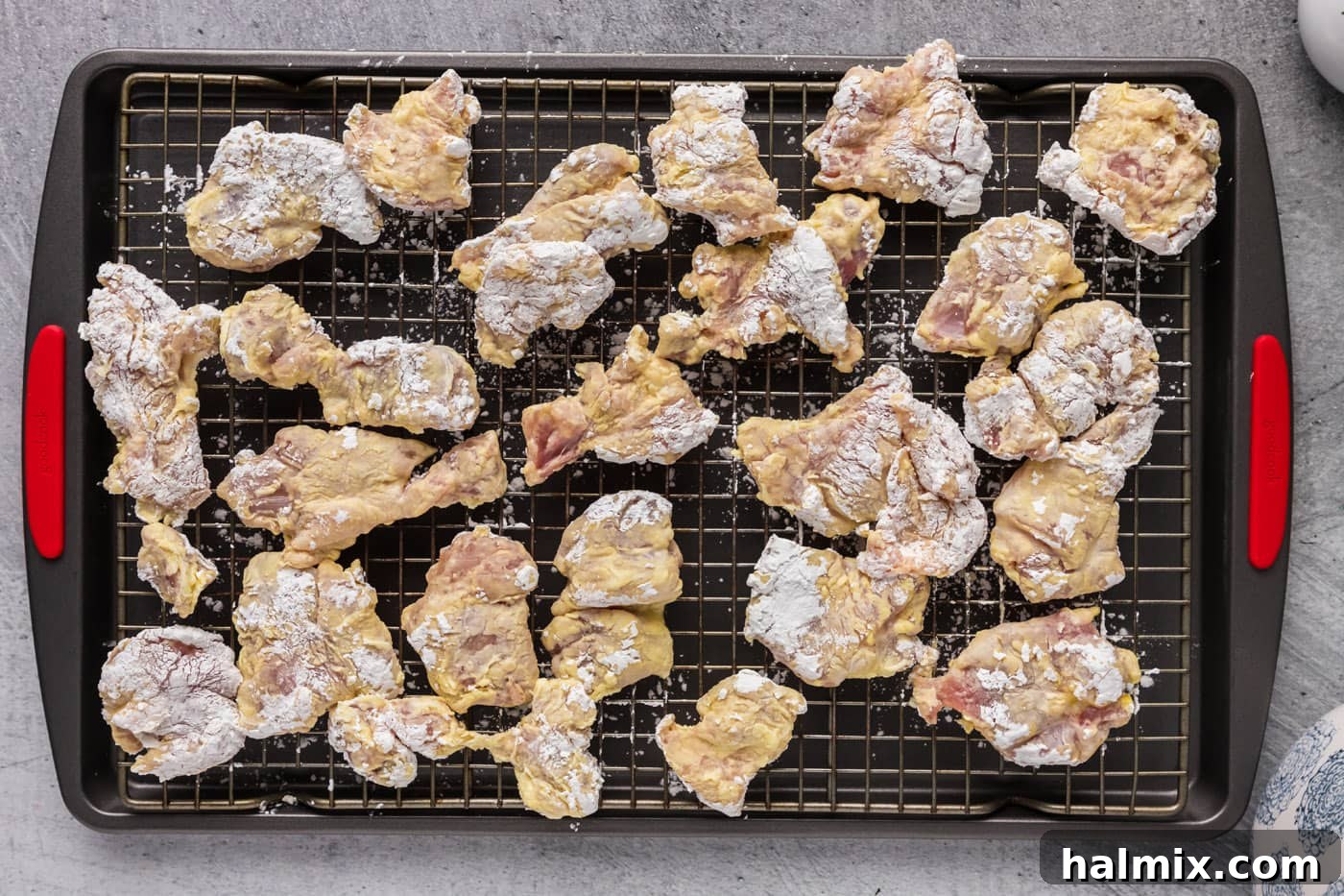 dredged chicken pieces on a wire rack
