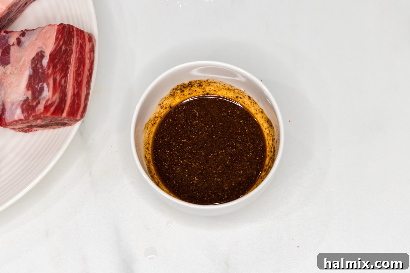 Olive oil and Mexican seasoning are mixed together in a small bowl, forming a ready-to-use rub.