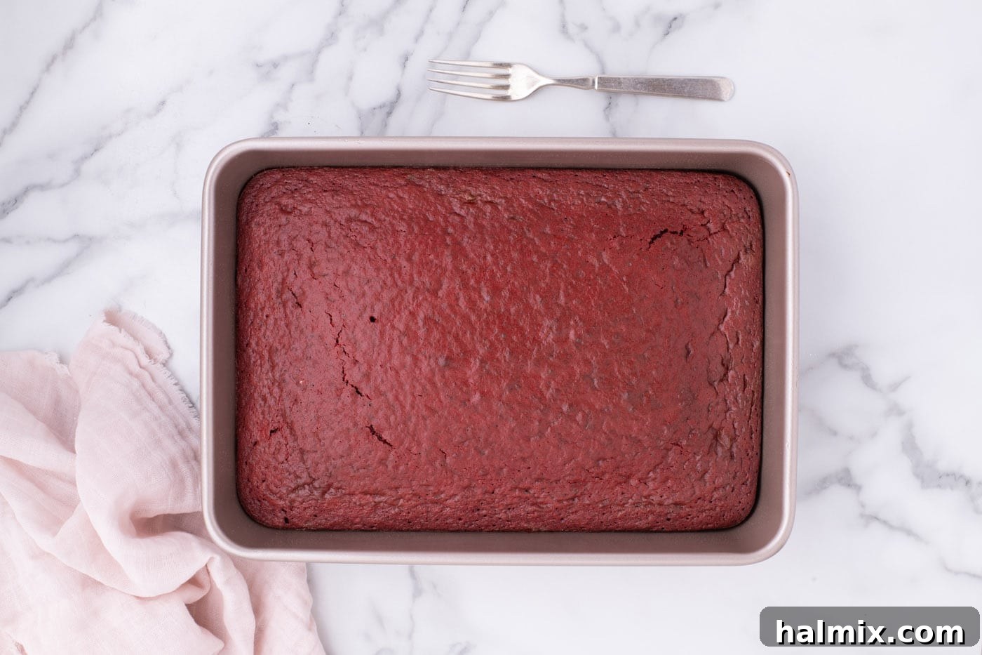 Freshly baked red velvet cake cooling in a 9x13 inch pan