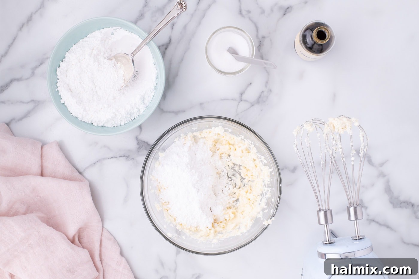 Adding powdered sugar gradually to the cream cheese and butter mixture