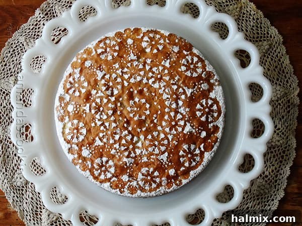 A beautifully decorated Merryfield apple cake on a white platter, invitingly presented for autumn gatherings.