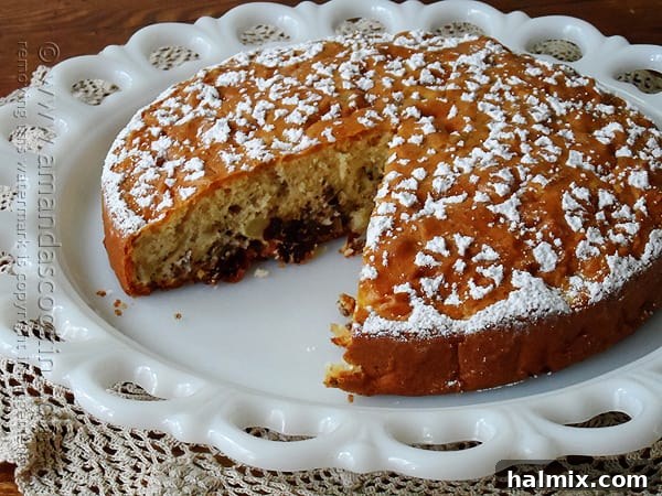 A close-up view of a Merryfield apple cake on a decorative platter, highlighting its inviting texture and golden-brown crust.