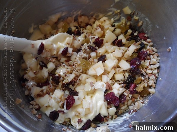 The rich, lumpy batter for the Merryfield Apple Cake, studded with apples, nuts, and dried fruits, mixed in a large bowl.