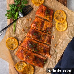 Two fillets of Smoked Salmon resting on parchment paper on a wooden board