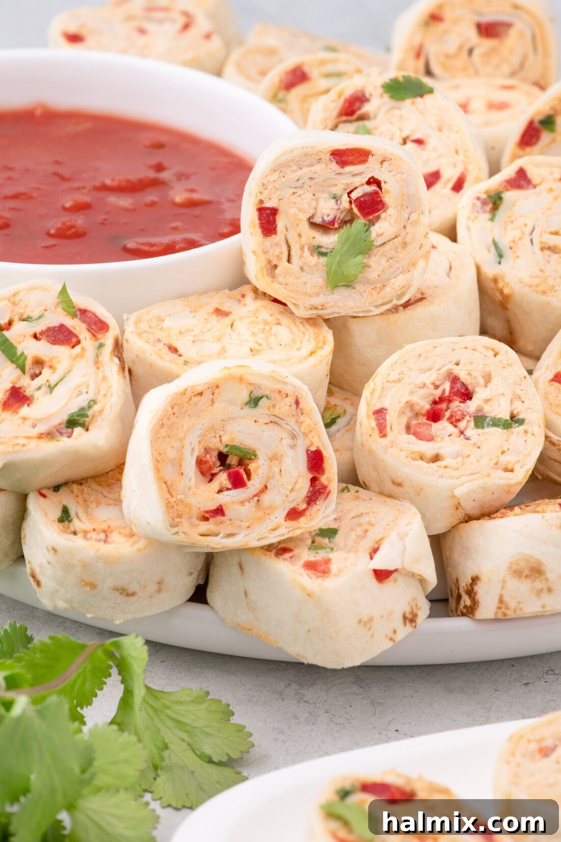 Mexican Pinwheels on a plate with salsa in a bowl