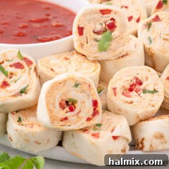 Close up photo of Mexican Pinwheels on a plate with a bowl of salsa in the background