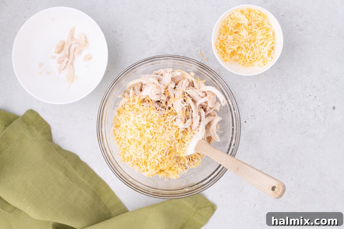 adding shredded chicken and cheese to mexican pinwheel filling