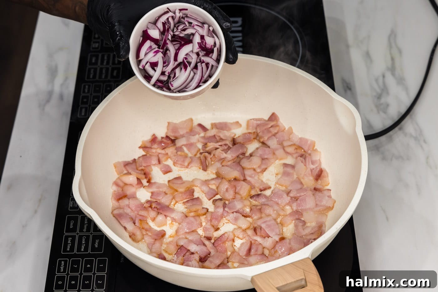 Fiery Fried Cabbage 6 adding sliced onion to pan of partially cooked bacon