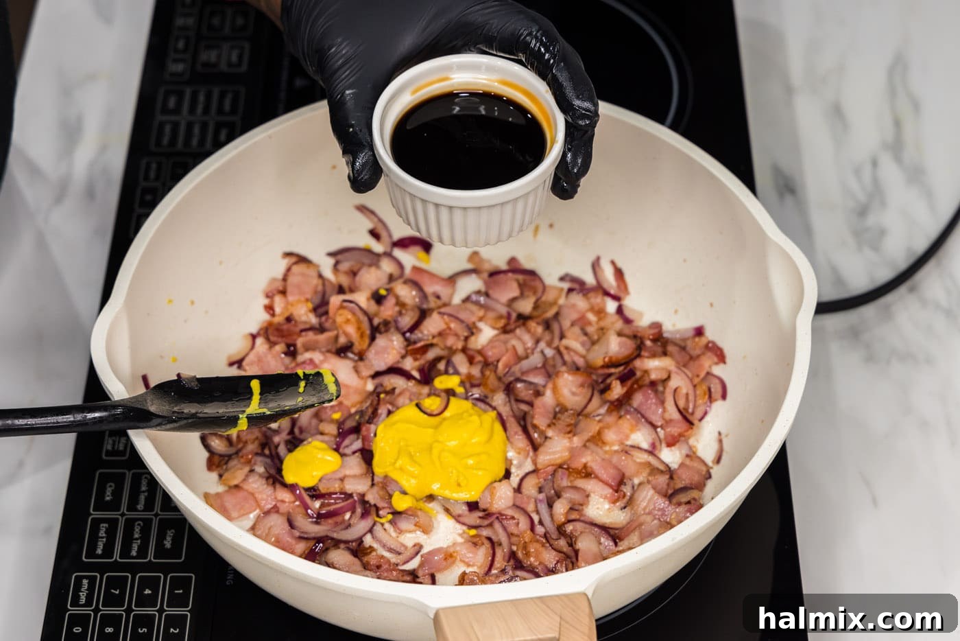 Fiery Fried Cabbage 7 adding soy sauce to skillet with bacon, mustard, and onions