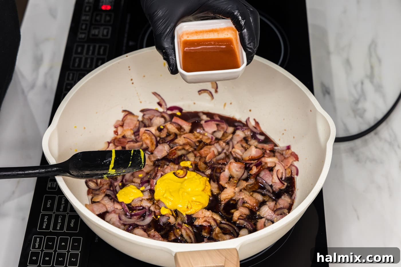 Fiery Fried Cabbage 8 adding hot sauce to mixture of bacon, mustard, onions, and soy sauce in a skillet