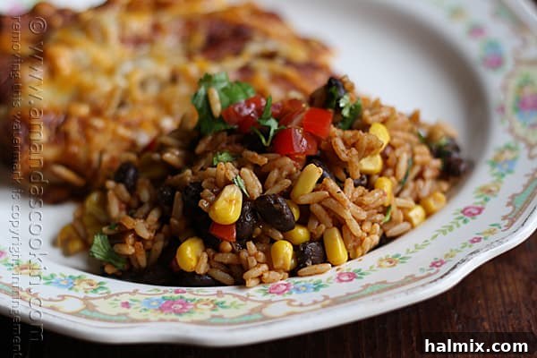 A vibrant close-up of Spanish rice with black beans and corn, garnished with fresh cilantro and diced tomatoes.