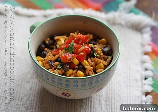 A beautiful close-up of Spanish rice with black beans and corn in a teal and white bowl, ready to be enjoyed.