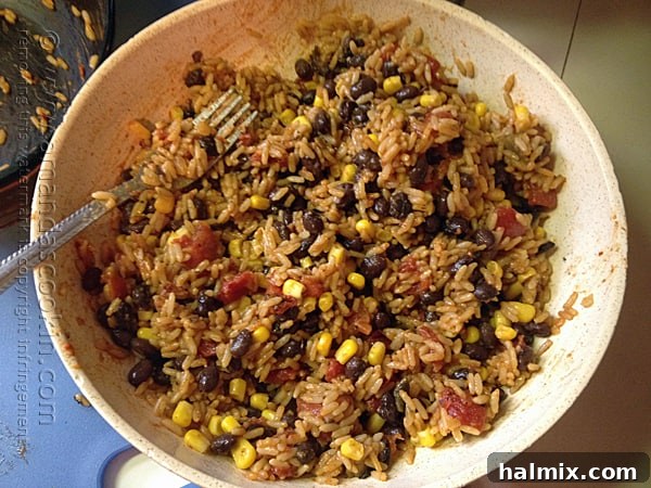 A bowl of freshly cooked Spanish rice, ready for the next step of mixing in the beans and corn.