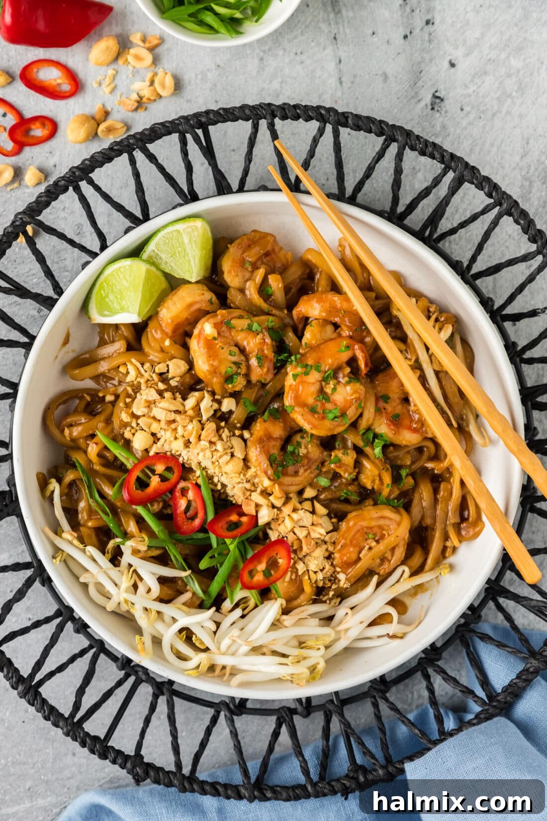 Vibrant Shrimp Pad Thai 2 A beautifully presented bowl of Shrimp Pad Thai, garnished with fresh herbs and peanuts, ready to be enjoyed with chopsticks.