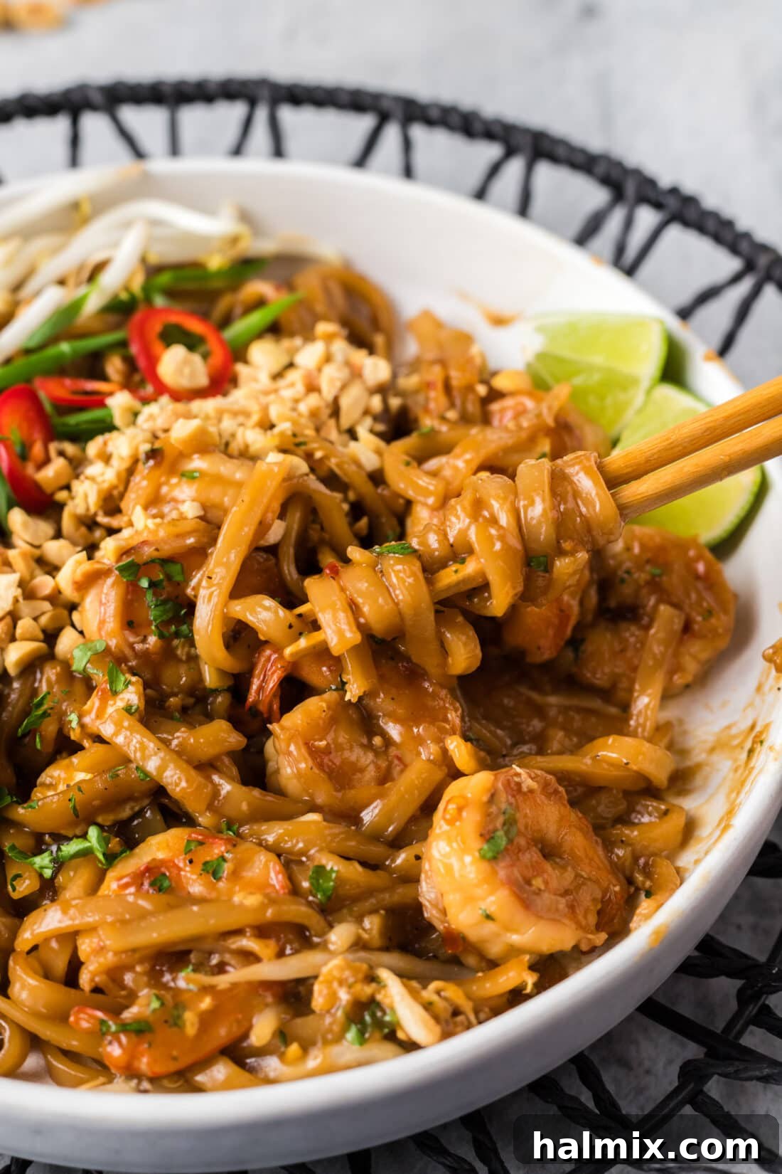 Vibrant Shrimp Pad Thai 12 A close-up of Pad Thai noodles elegantly wrapped around chopsticks, emphasizing the texture and deliciousness of the dish.