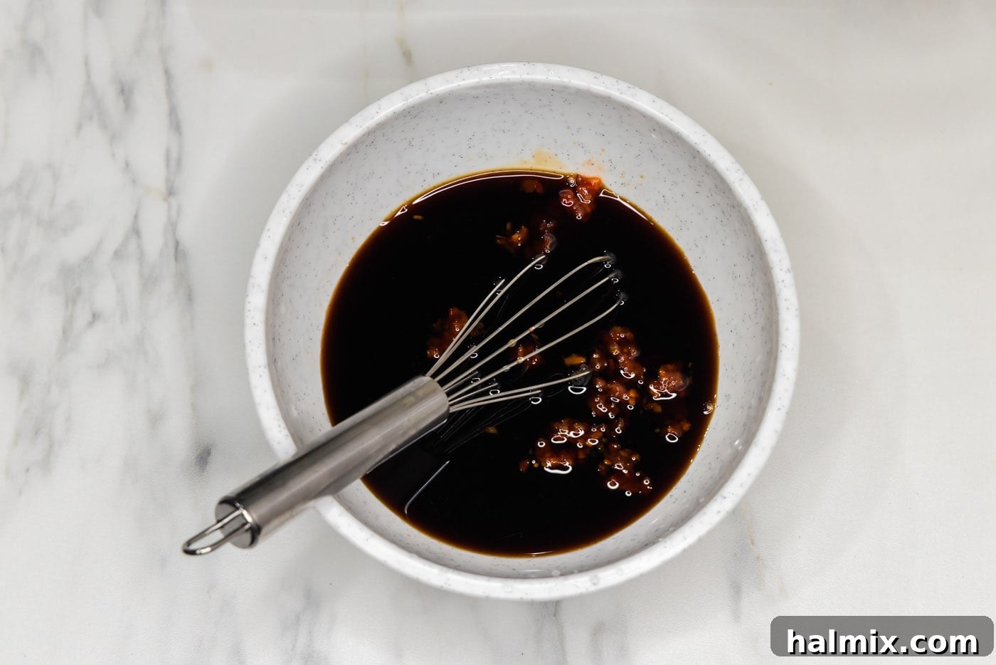 Pad Thai sauce mixture being whisked in a bowl.
