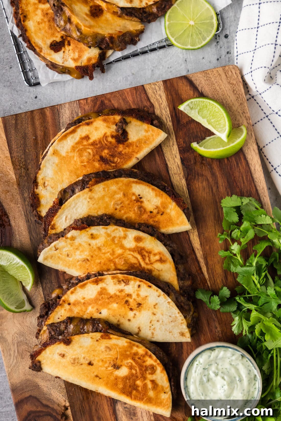Black Bean Tacos on a wooden board with limes and dipping sauce