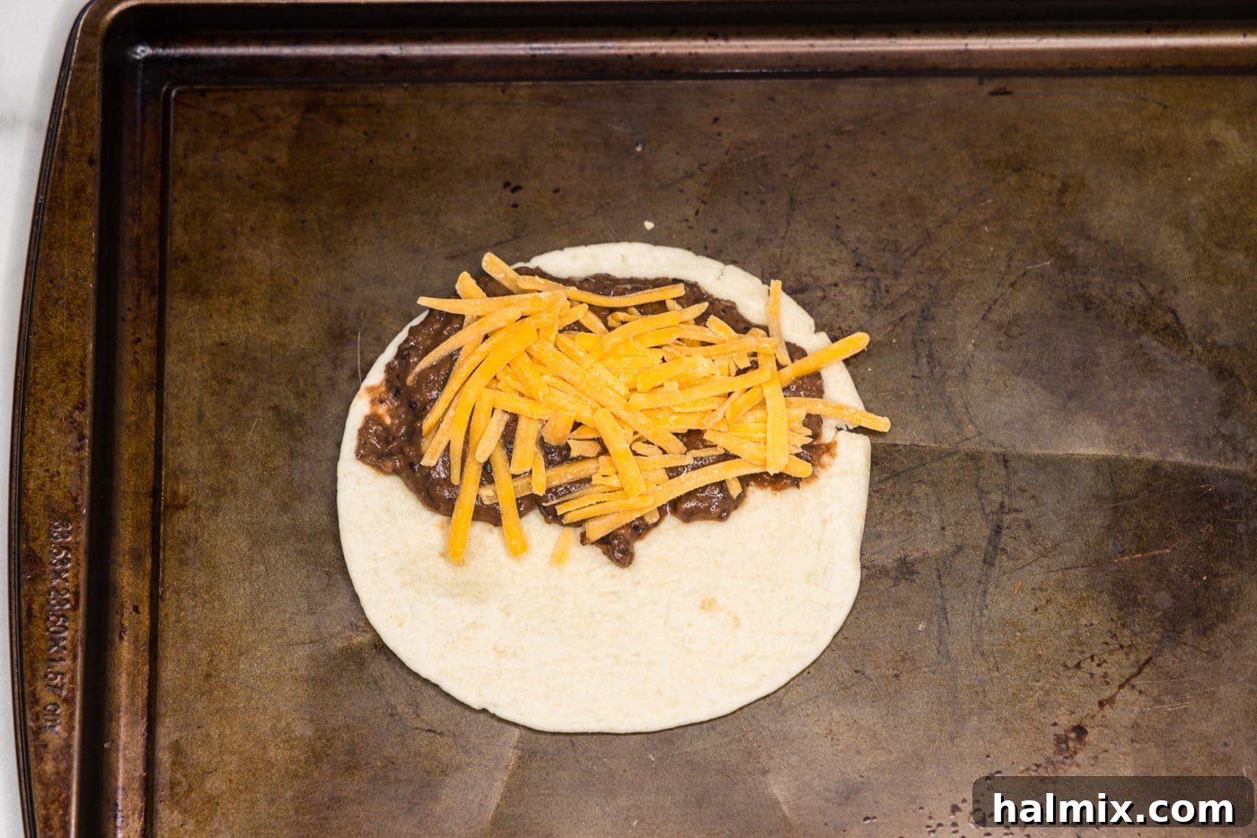 shredded cheddar cheese on top of black bean mixture